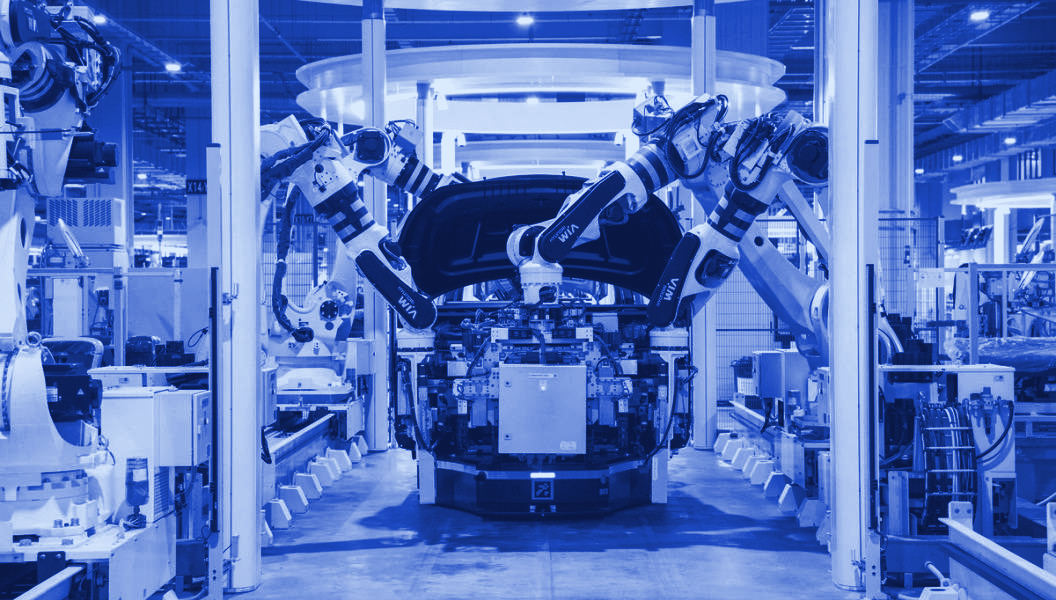 Robotic arms assembling a car on a factory line