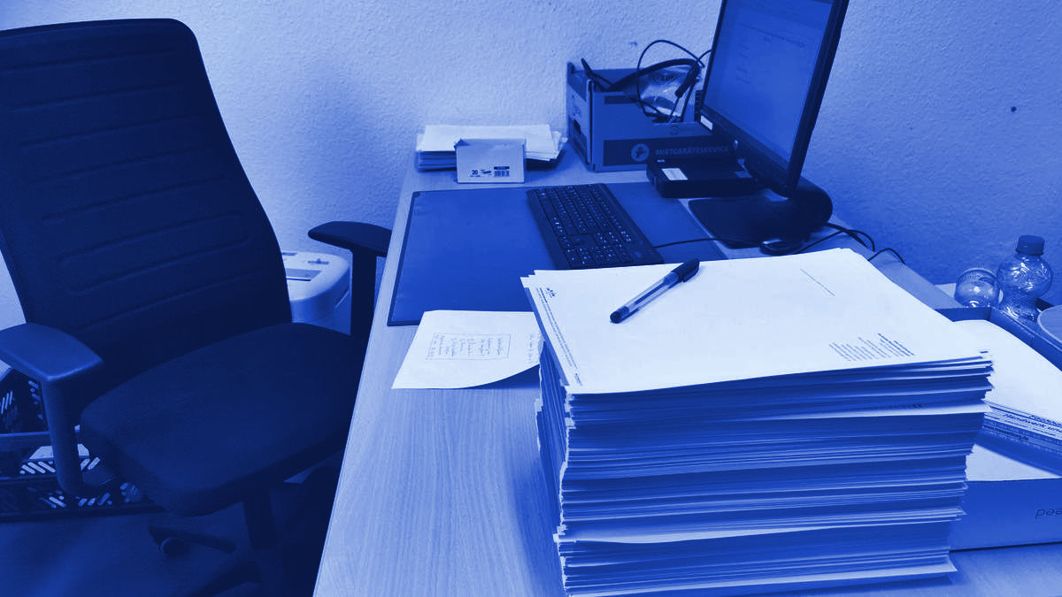 A desk cluttered with documents and files