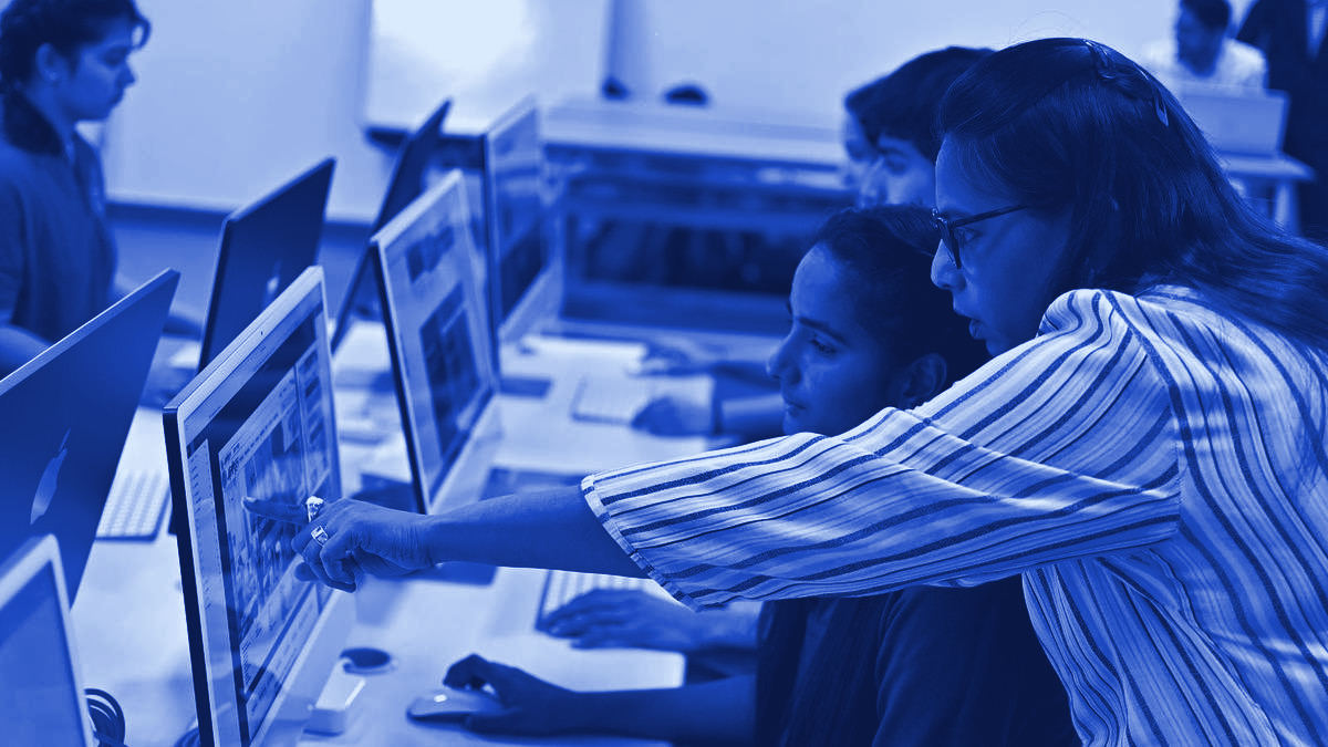 An Indian student working at a computer in a lab