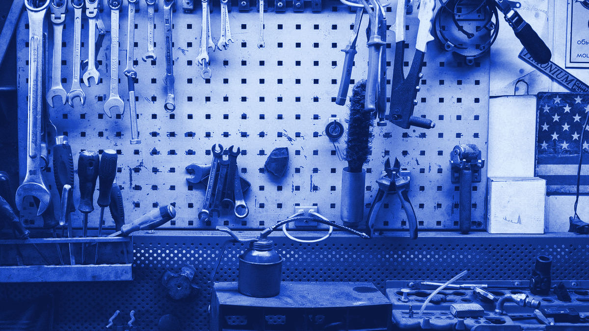 A power tool and hand tools arranged on a workbench