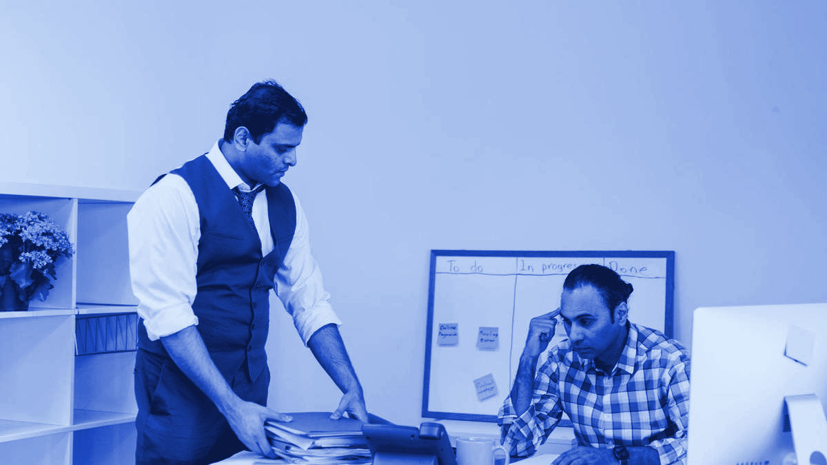 Two professionals in discussion across a desk