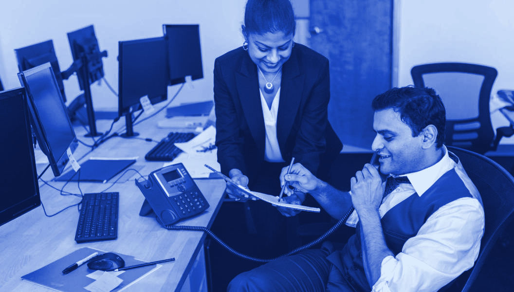 A group reviewing work around a table in an office